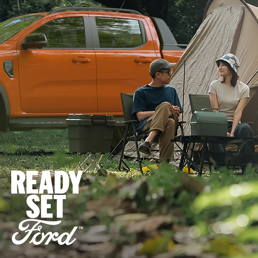 ford-overview-vn-mossaic-996x996-eye-level-side-view-of-a-bright-orange-pickup-against-muted-green-forest-tones-desktop